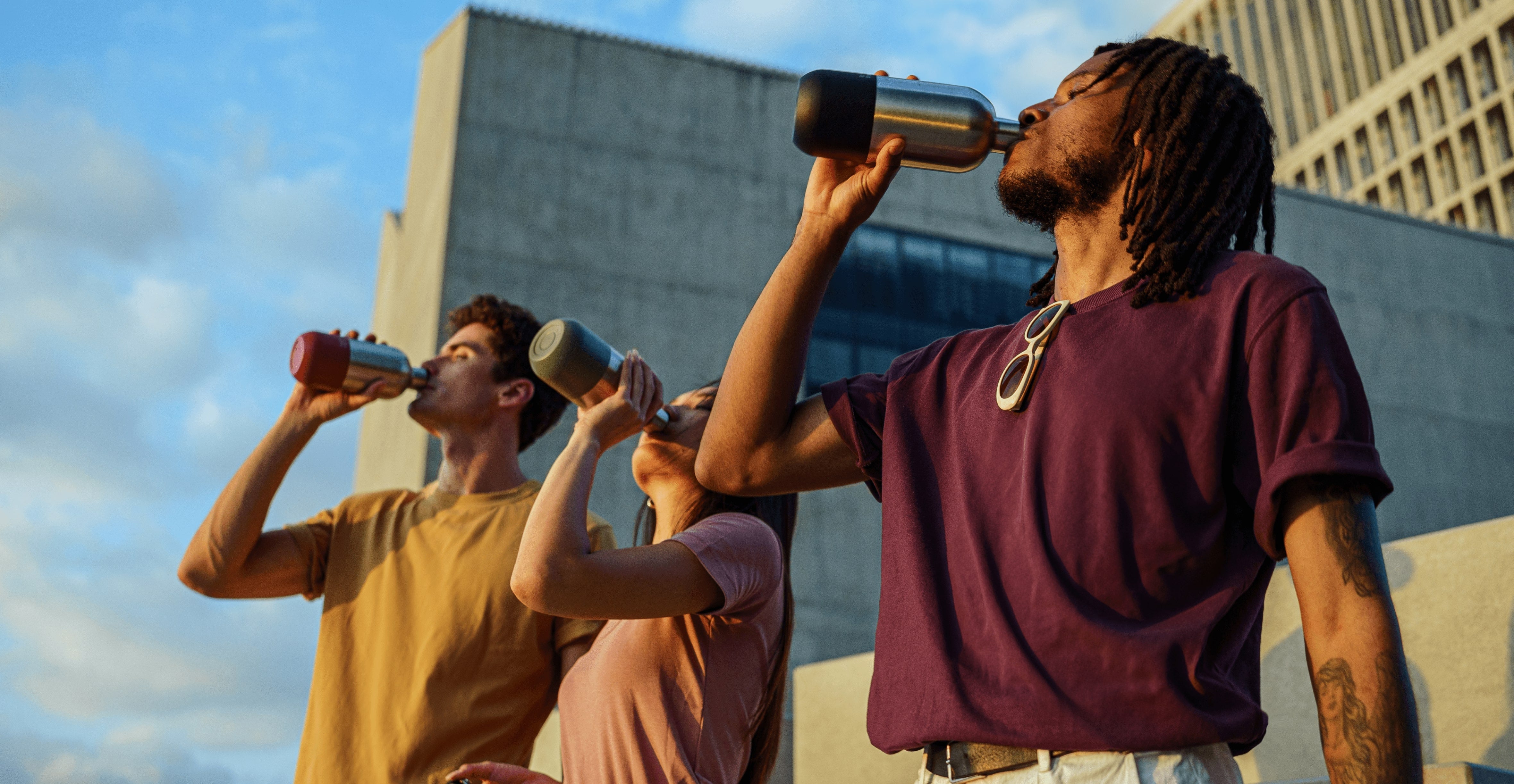 Drei Models trinken aus noma noma Thermosflaschen im Sommeruntergang